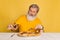 Displeased gray bearded man tasting italian pizza with cheese isolated on yellow studio background.