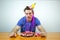 Displeased unhappy caucasian man with cone hat on head and crumple cake  looking down with bored dissatisfied expression as his bi