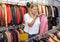 Displeased woman choosing leather clothes