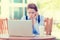 Displeased worried business woman sitting in front of laptop computer