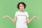 Displeased young brunette woman in white volunteer t-shirt isolated on pastel green wall background studio portrait