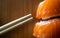 Disposable bamboo chopsticks and salmon sushi closeup on wooden background