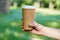 Disposable coffee cup on table on man\'s hand