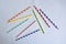 Disposable colorful striped paper cocktail sticks lie chaotically on light blue background. Eco friendly paper drinking straws.