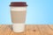 Disposable cup with  hot drink on the wooden planks, 3D rendering