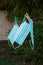 Disposable fabric medical masks of blue color hang on a clothesline on the street after washing on a summer day, fixed with clothe