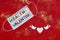 Disposable protective covid face mask with red heart on a red background. Safe Valentine`s day concept during coronavirus pandemic