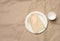 Disposable round white paper plate and cup on brown paper background