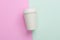 Disposable takeaway take out coffee cup on light blue and pink