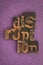 Disruption, word written with vintage letterpress printing blocks on textured purple background