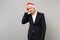 Dissatisfied business man in Christmas hat putting hand on head, having headache isolated on grey background