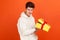 Dissatisfied frustrated teenager in casual hoodie holding open gift box, upset with bad present, unjustified expectations