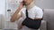 Dissatisfied man in foam cervical collar and arm sling talking phone, problem