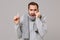 Dissatisfied tired young man in gray sweater, scarf isolated on grey background studio portrait. Healthy lifestyle ill