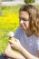 Dissatisfied unhappy teen girl eats tasteless ice cream in a waffle cone in summer. Selective focus