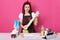 Dissatisfied woman kneading dough, baking cake or pie, housewife bakes at home, brunette lady surraunded products, dislikes to