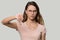 Dissatisfied woman showing thumb down disapproval gesture studio shot