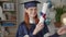 distance learning, adult female graduate in academic clothes rejoices diploma online, takes out certificate from an