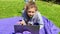 Distance learning outdoor. Girl lying on green grass with laptop