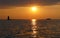 A distance silhouette of the lighthouse and a boat during sunset at Cape Henlopen State Park, Lewes, Delaware, U.S