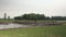 Distance view of motorbikes crossing a bamboo bridge over a small river with flooded banks (rural area) 