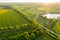 Distant Aerial View on Farmland with Rapeseed Fields and Pond on Sunny Spring Evening