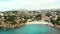 Distant aerial view rocky coves, sandy beach, tiny bay of Benissa. Turquoise bright blue Sea waters hillside townscape at sunny