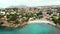 Distant aerial view rocky coves, sandy beach, tiny bay of Benissa. Turquoise bright blue Sea waters hillside townscape at sunny