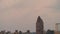 A distant airplane emerges from the clouds looking into the uptown NYC skyline