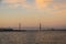 A distant bridge over a large body of water at sunset with