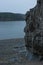 Distant cliffs across a body of water covered in tall green pine trees