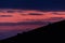 Distant horses silhouettes over a mountains against a beautiful coloured sky at dusk