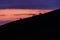 Distant horses silhouettes over a mountains against a beautiful coloured sky at dusk