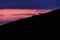 Distant horses silhouettes over a mountains against a beautiful coloured sky at dusk