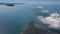 Distant islands in ocean and white cloud under airplane wing