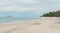 Distant lone girl contemplates braving the water at low tide