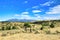 Distant mountain in Montana viewed beyond a farm fence and across a hilly field.