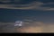 Distant night time thunderstorm over sea is illuminated by lightning