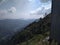 A distant panoramic rare view of mountains with dark clouds in blue sky