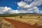 Distant rainbow over the rich red dirt of Maui.