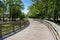 Distant runners on an elevated boardwalk through forest and wetlands