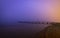 Distant silhouette of a person on a wooden jetty at dusk with a mysterious atmosphere