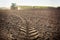 Distant tractor closeup fresh track on wet spring ground