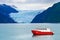 Distant view of a Holgate glacier with red boat in the foreground in Kenai fjords National Park, Seward, Alaska, United States,