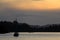 Distant view of a sailing boat against sunrise sky