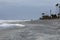 Distant walkers along the shoreline during a storm, heavy seas and foam