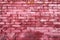 Distinctive pink brick wall textured with aged, shabby, cracked paint