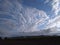 A distinctive snapshot of a beautiful panoramic view green fields and a pattern of clusters of white clouds in sunlight