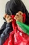 A distraught Afghan woman in a traditional headdress holds the flag of Afghanistan in her hands. concept, drama of persecuted wome