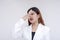 A distressed and irritated young woman pinching her nose to avoid a stinky smell. Isolated on a white background